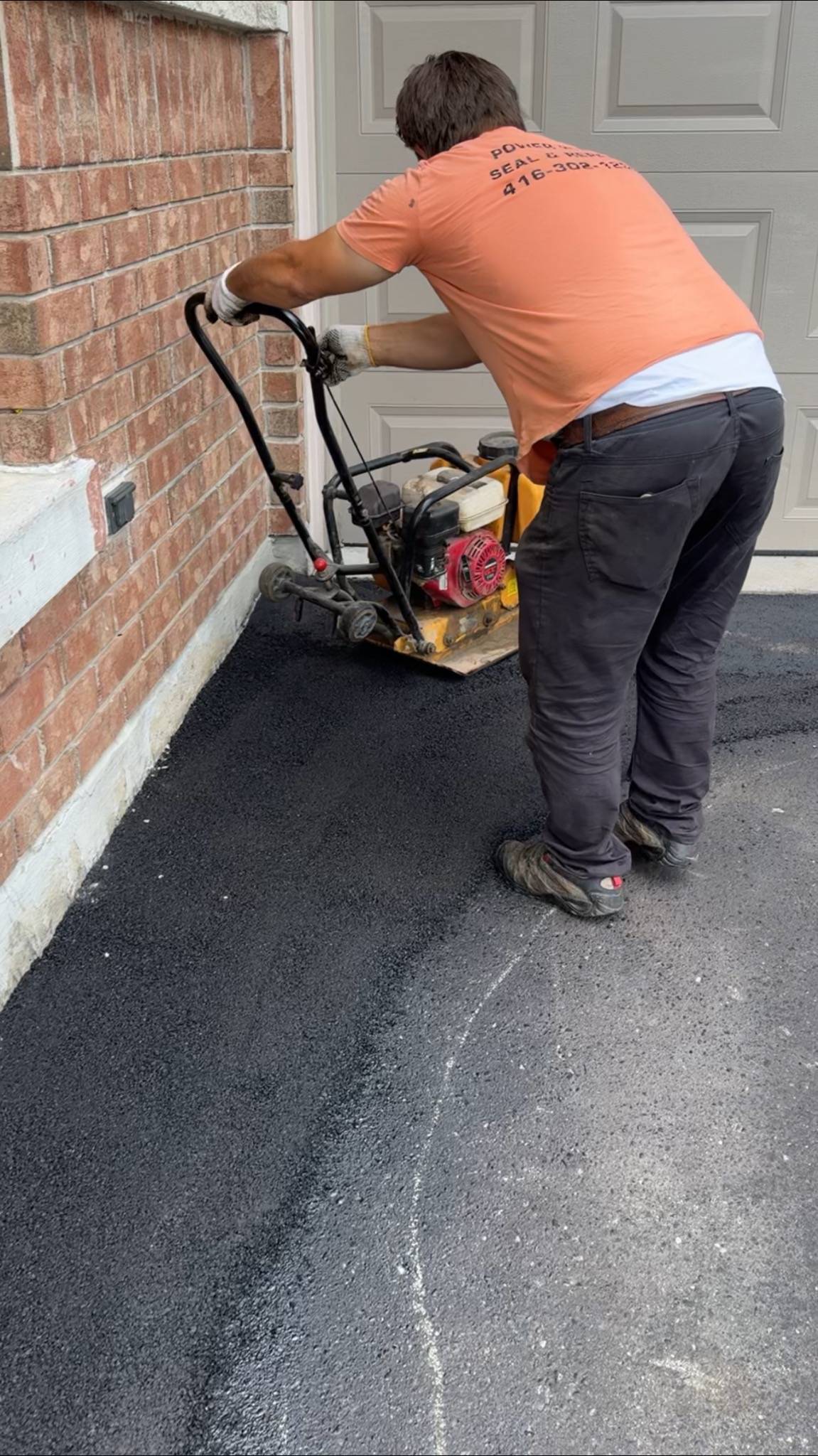Compact finish of asphalt repair near garage