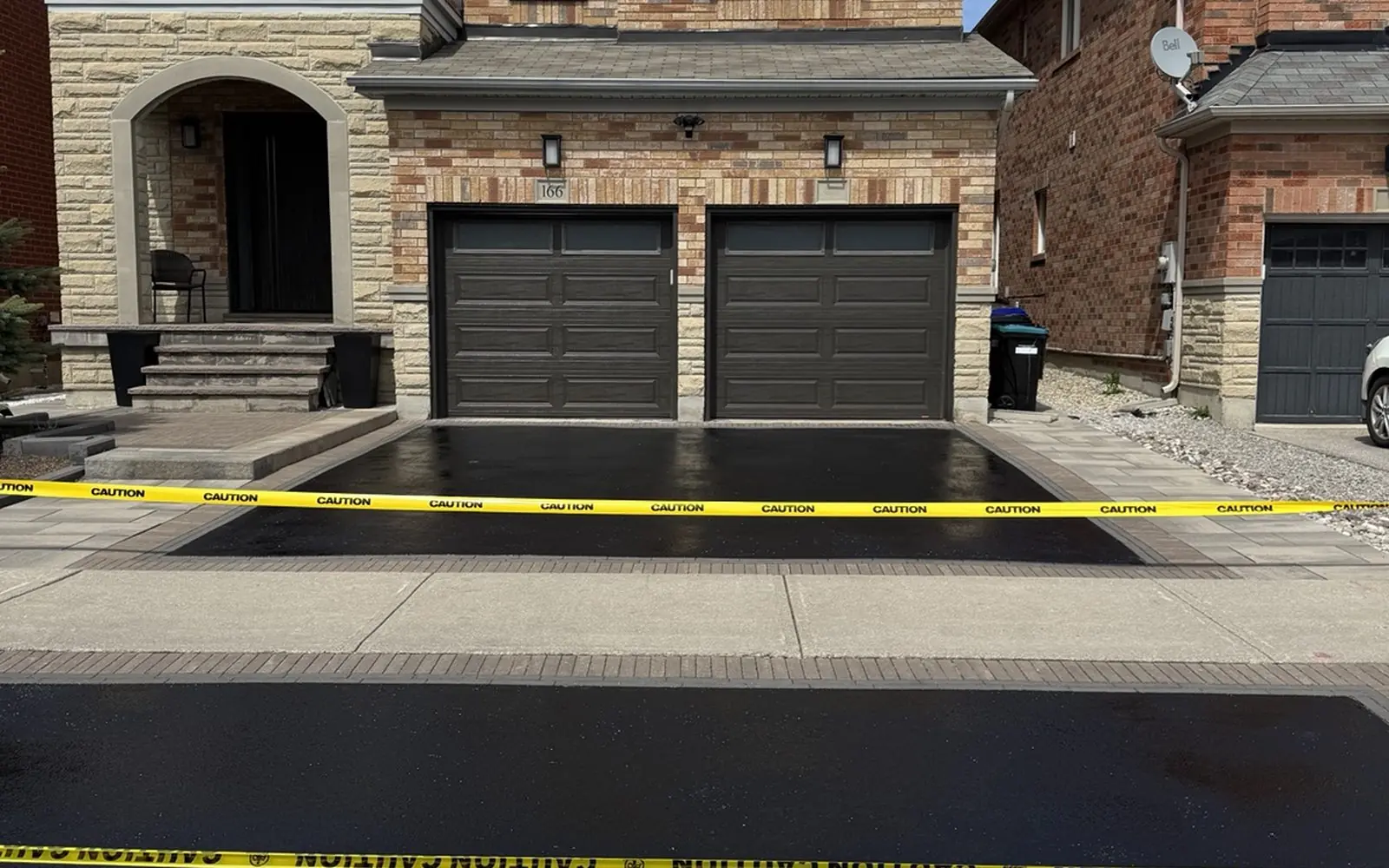 Fresh blacktop sealant on newly sealed driveway