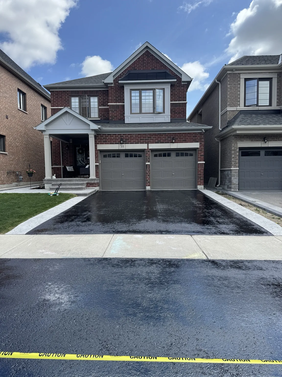 Fresh oil-based driveway sealing on a double garage home