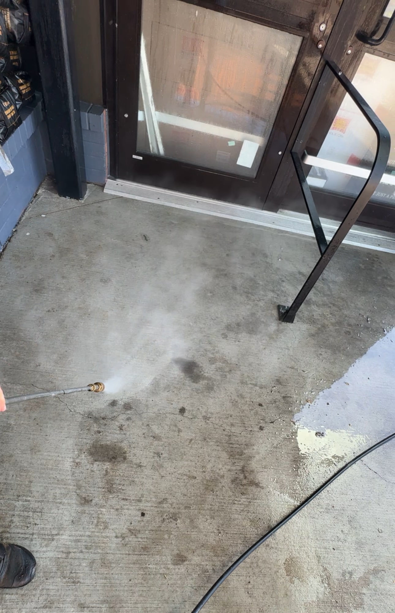 Pressure washing dirty tiles with visible clean lines